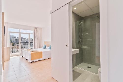 伊维萨镇Suncoast Ibiza Hotel - Adults Only -的带淋浴的浴室和客房内的一张床