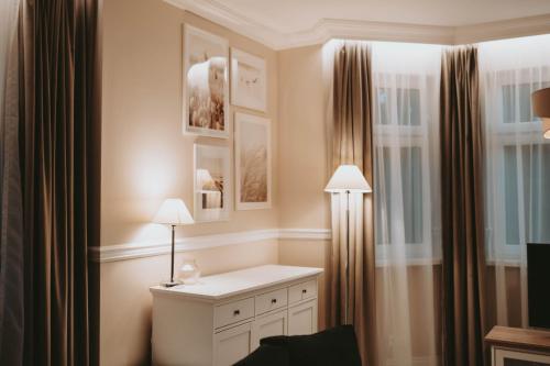 波兰尼卡-兹德鲁伊Villa Adele的客房设有一张带两盏灯的桌子和一扇窗户。