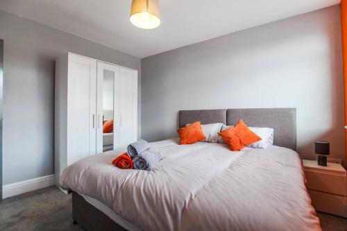 布里斯托PRIME LOCATION - Modern Central Apartment的一间卧室配有一张带橙色枕头的大床