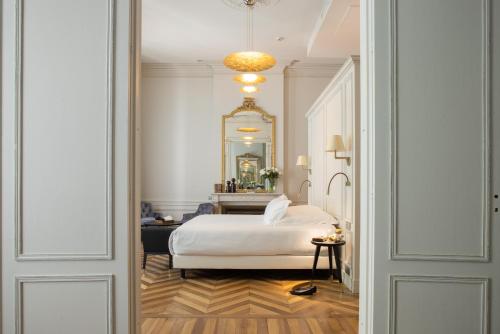 波尔多Villas Foch Boutique Hotel & Spa Bordeaux的卧室配有白色的床和镜子