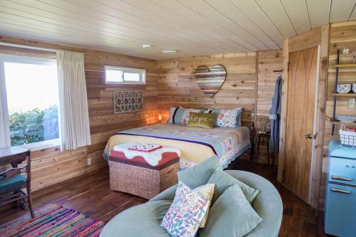 塞奎姆Dungeness Bay Cottages的一间卧室配有一张床和一个沙发
