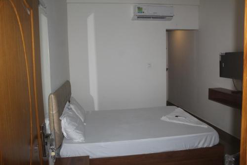 科钦Grace Apart Hotel @Kochi的一间小卧室,房间内设有一张白色的床