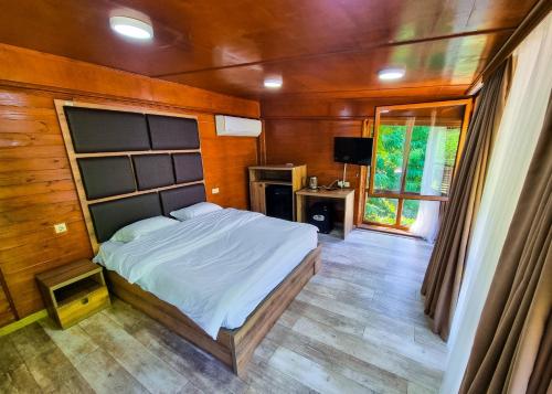 科布列季Mtirala National Park hotel ORBEZA的一间卧室设有一张大床和一个窗户。