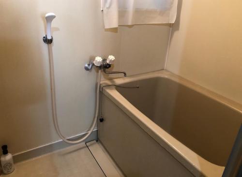 熊本Chambord Kyomachi 102 - Vacation STAY 67038v的浴室内配有带软管的浴缸