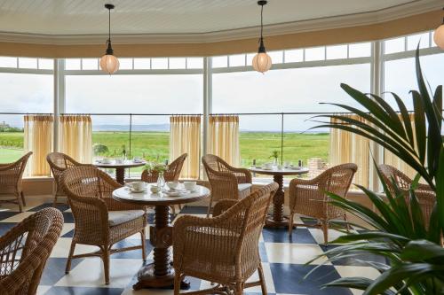 特伦Marine Troon的餐厅设有桌椅和大窗户。