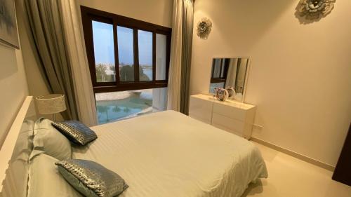 塞拉莱WASAN LUXURY RESIDENCE HAWANA Salalah的一间卧室设有一张床和一个大窗户