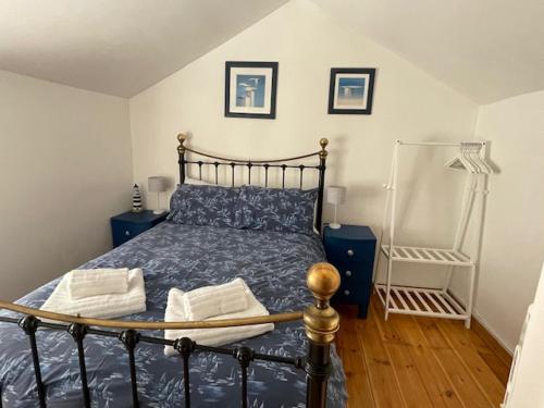 毛斯尔Honeysuckle Cottage by The Sea的一间卧室配有一张带蓝色棉被的床