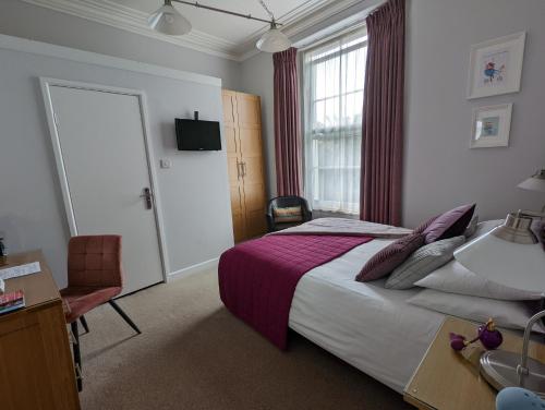 托基滨海别墅酒店的一间卧室配有一张床、一张书桌和一个窗户。