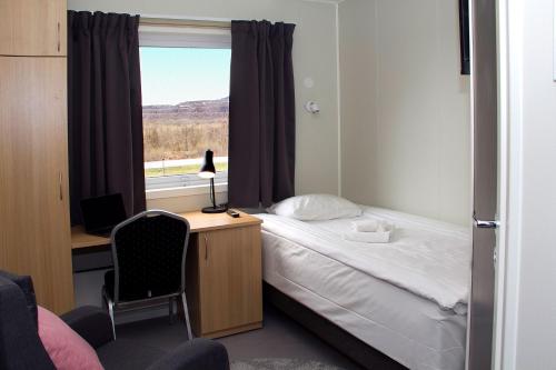 基律纳Kiruna City Room的一间卧室配有一张床、一张书桌和一个窗户。
