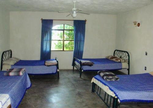 库奥特拉莫雷洛斯Casa De Descanso Cuautla Morelos的带三张床和窗户的客房