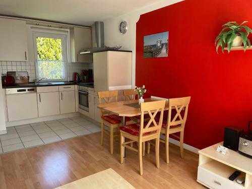卢布明Semi-detached house, Lubmin的厨房配有桌子和红色的墙壁
