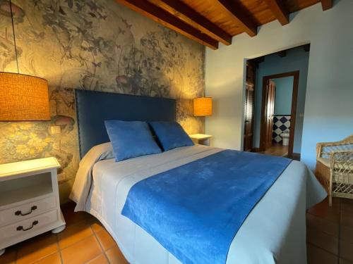 坎德莱达Posada Albarea的一间卧室配有一张带蓝色床单的大床
