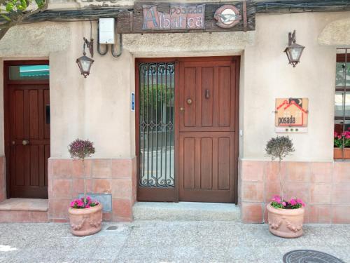 坎德莱达Posada Albarea的两棵盆栽植物的建筑物的前门