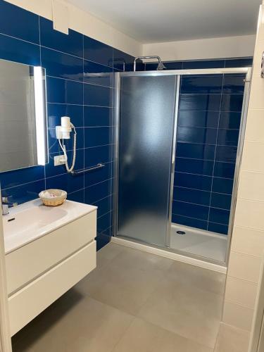 贝尔杰吉Torre del mare Rooms的蓝色瓷砖浴室配有淋浴和盥洗盆