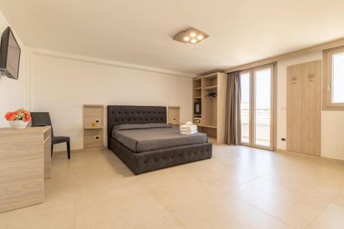 托雷圣乔万尼乌Room Salento Palace的一间卧室配有一张床、一张书桌和一台电视
