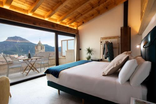 塞古拉 - 德拉谢拉Hotel Poeta Jorge Manrique的一间卧室设有一张床和一个大窗户