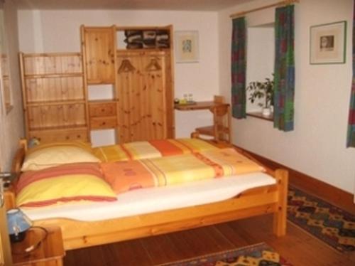 里肯巴赫Pension Sonne的一间卧室,卧室内配有一张木床