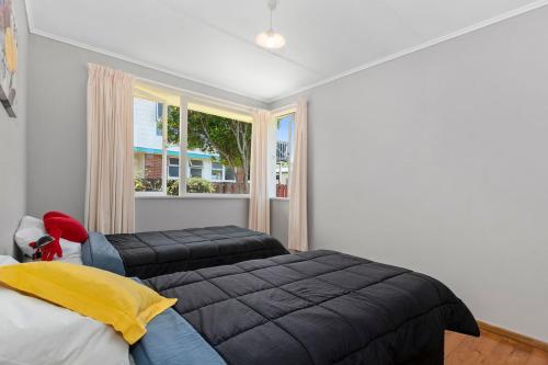 鲁阿卡卡Kulukulu - Ruakaka Holiday Home的一间卧室设有两张床和窗户。