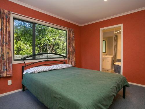 陶波Laid Back on Lakewood - Taupo Holiday Home的一间卧室设有一张床和一个大窗户