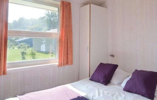 特拉弗明德Strandblick 14 - Dorf 1的窗户客房内的一张带紫色枕头的床