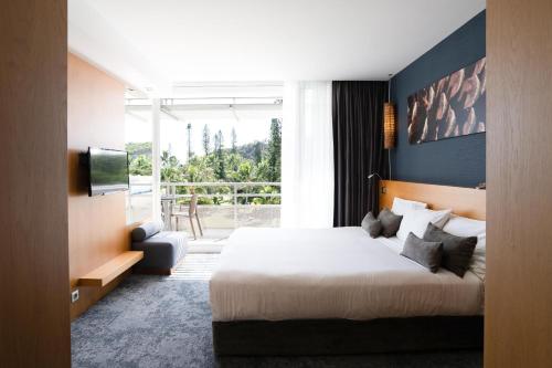 努美阿城堡皇家海滩度假村及Spa，努美阿的酒店客房设有一张床和一个大窗户