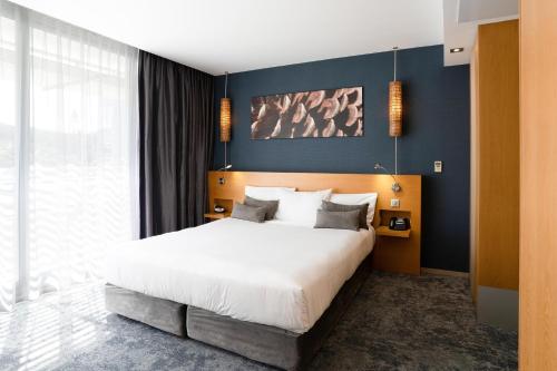 努美阿城堡皇家海滩度假村及Spa，努美阿的一间卧室设有一张大床和蓝色的墙壁
