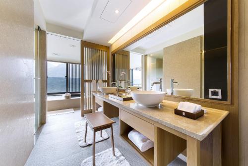 台北北投丽禧温泉酒店的一间带三个水槽和大镜子的浴室
