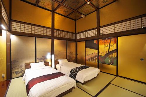 高山Hidatakayama Ukiyoe INN Garon - Vacation STAY 12320v的墙上挂有绘画的客房内的两张床