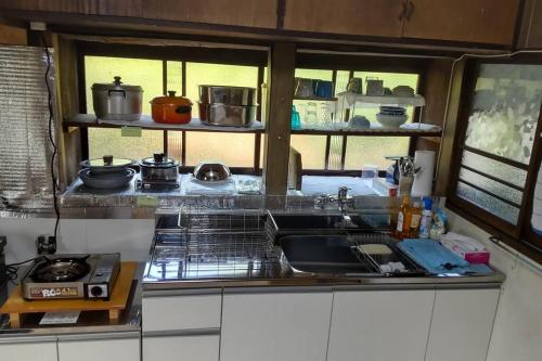 挂川市古民家リゾートハウス　ひみつきち的厨房配有水槽和炉灶