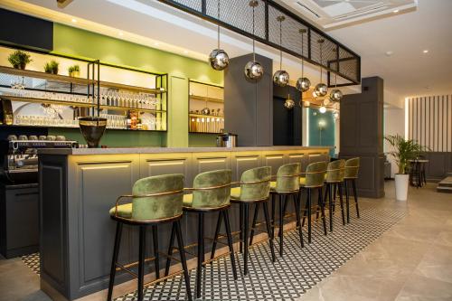 博斯特里Maison的一间酒吧,拥有绿色的墙壁和绿色的凳子