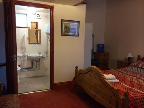 里伯斯谷地霍顿The Crown Hotel的一间卧室配有一张床,浴室设有水槽