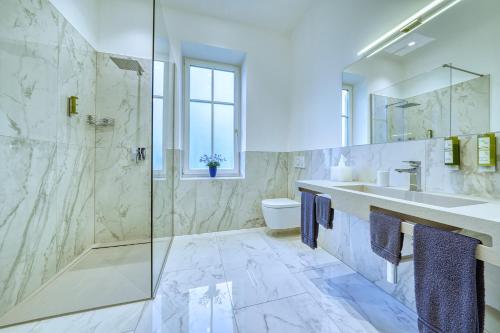 梅拉诺Villa Tell rooms and suites的带淋浴、盥洗盆和卫生间的浴室
