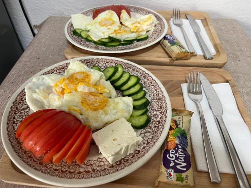 泰托沃Kitka Hostel - Vratnica的两盘食物,桌上有鸡蛋和蔬菜