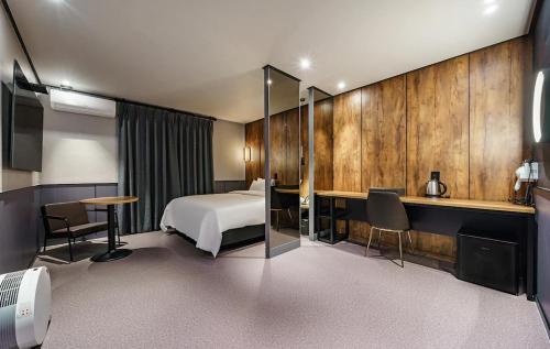 仁川市Brown-Dot Hotel Geomdan的配有一张床和一张书桌的酒店客房