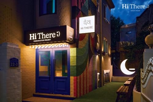 首尔Hithere guesthouse的一座建筑,上面有蓝色的门和标志