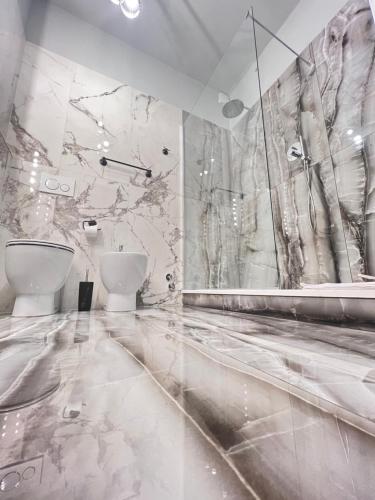佛罗伦萨Residenza Anton Doni的一间带两个卫生间和大理石墙的浴室