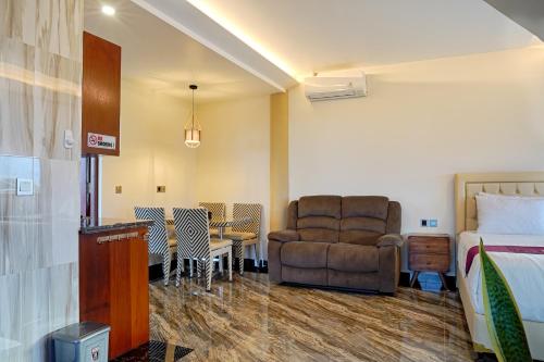 坎古Kyara Villa Apartments的配有床、椅子和桌子的酒店客房
