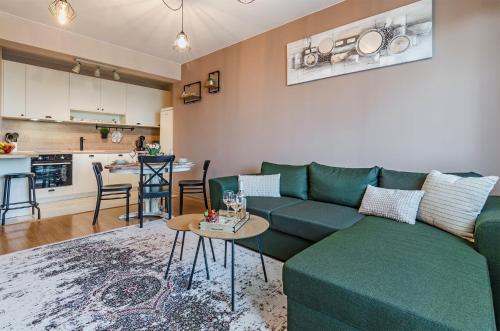 布尔加斯Апартаменти Ивайло / Ivaylo apartments的一间带绿色沙发的客厅和一间厨房