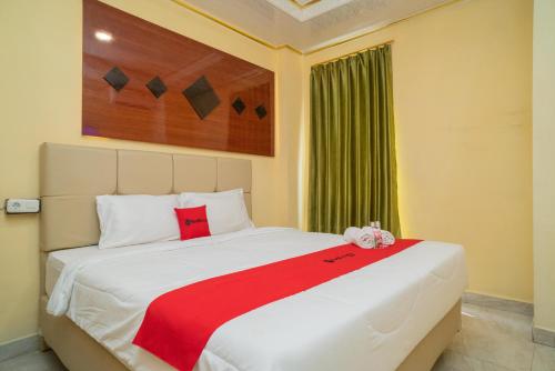 KandangsapiRedDoorz Plus Syariah near Pasar Turi的卧室配有一张大白色床和红色毯子