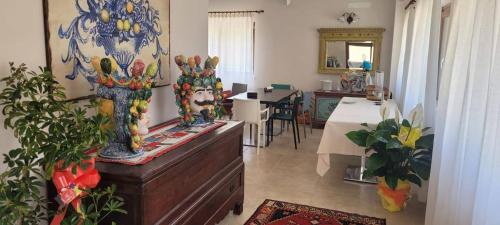 恩纳Agriturismo Borgo Furma的一间在梳妆台上放两个花瓶的房间和一间用餐室