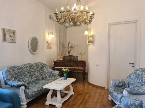 第比利斯洛厄尔酒店的客厅配有两张沙发、一张桌子和一架钢琴
