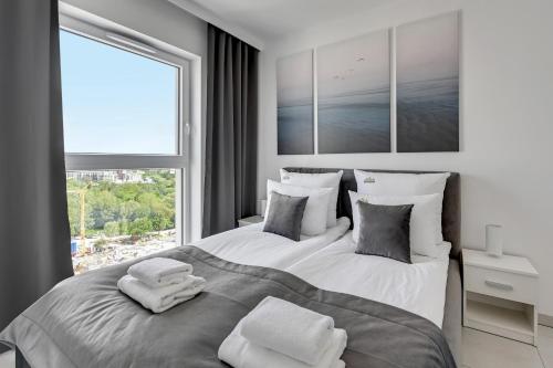 格但斯克Downtown Apartments Sea View Letnica Tower的一间卧室设有两张床和大窗户