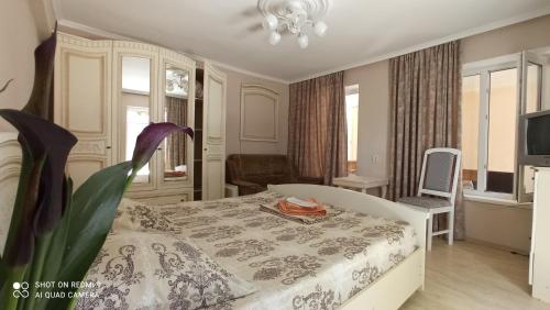加格拉Samira的一间卧室配有一张床和一张带花卉的桌子