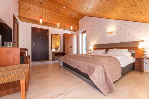 帕兰加Palanga Park Hotel的一间卧室设有一张大床和木制天花板