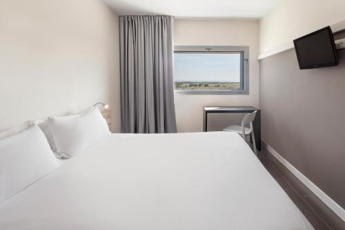 阿尔巴塞特B&B HOTEL Albacete的卧室设有一张白色大床和一扇窗户。