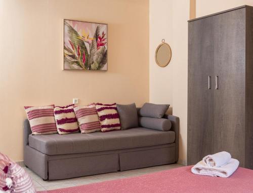 波罗斯Theano Hotel的客厅配有灰色的沙发和橱柜。