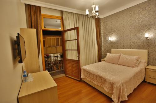 比于卡达Mimoza Butik Otel Buyukada的一间卧室设有一张床,并有通往阳台的门
