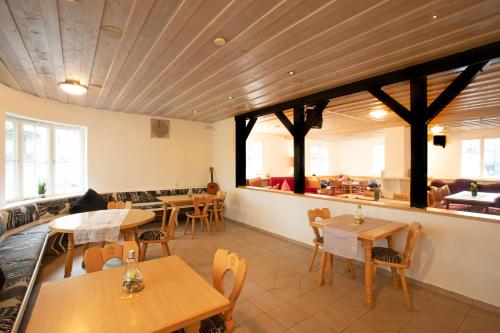 林道Hostel Westküste的一间带木桌和椅子的餐厅和一间自助餐厅