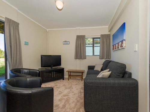 Sandy Doorstep - Whangamata Beachfront Apartment的休息区