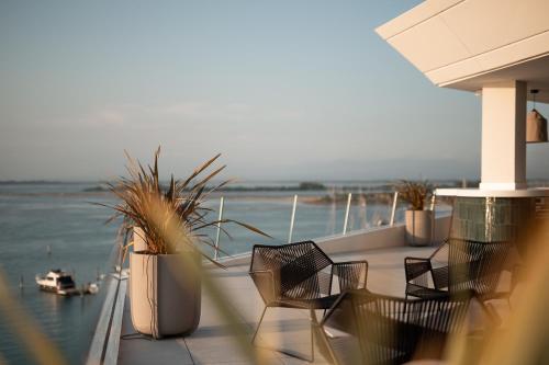 格拉多Laguna Faro Suites - Adults Only & Free Beach的阳台配有椅子,享有水景